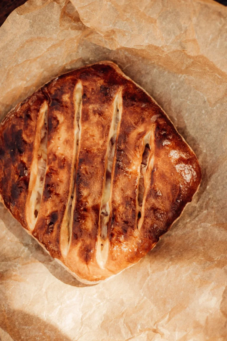 Top view of freshly baked rustic bread with golden crust on parchment paper perfect for culinary themes