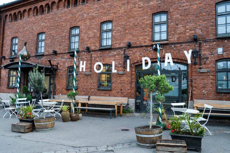 Cozy cafe in Helsinki with outdoor seating and vibrant plants perfect for relaxing moments