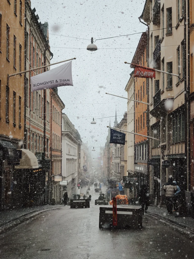 Snowfall envelops a bustling historic street in Stockholm Sweden creating a serene winter atmosphere 1